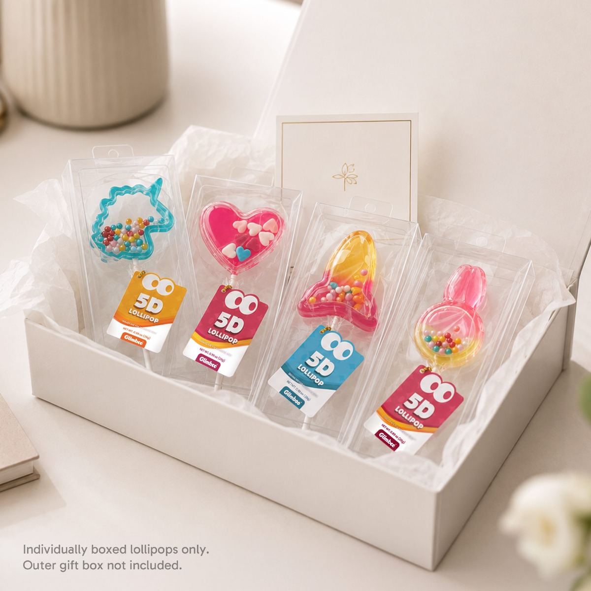 Glimboo 5D lollipops arranged in an open gift box with a note that the outer gift box is not included.